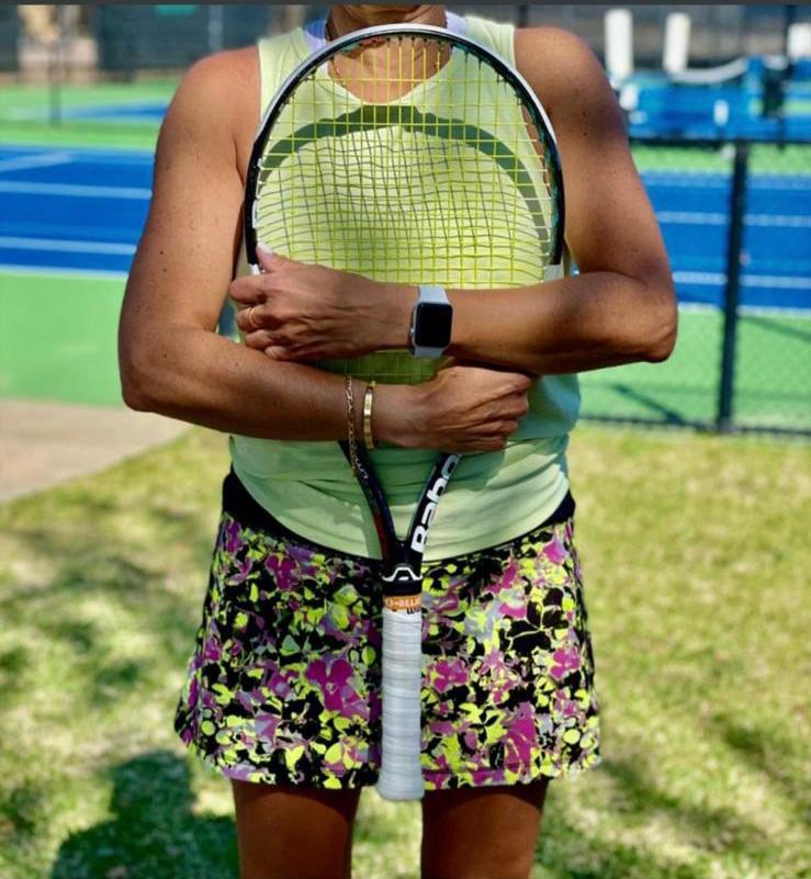 Tennisspielerin hält einen Tennisschläger vor dem Körper auf dem Tennisplatz